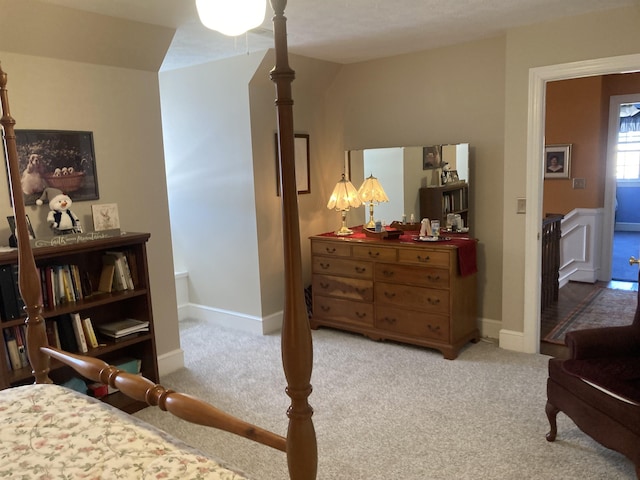 bedroom featuring light carpet and baseboards