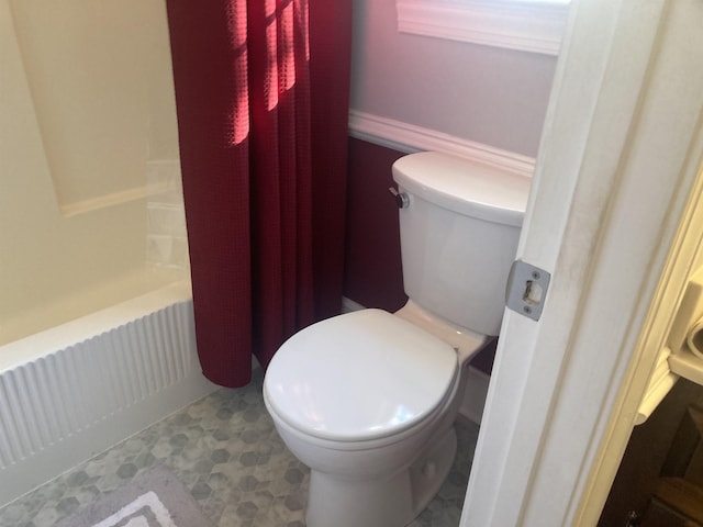 bathroom with shower / tub combo, toilet, and tile patterned floors