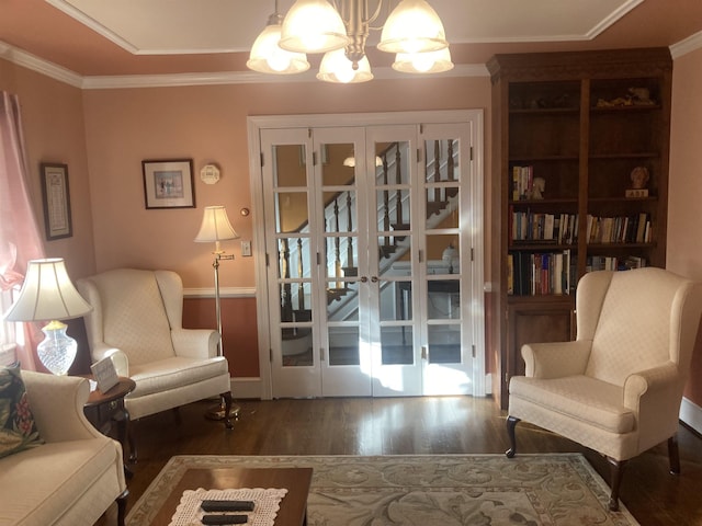 living area featuring a chandelier, dark wood-style flooring, baseboards, french doors, and crown molding