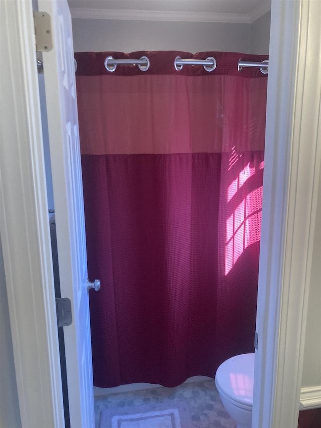 bathroom featuring a shower with shower curtain, crown molding, and toilet