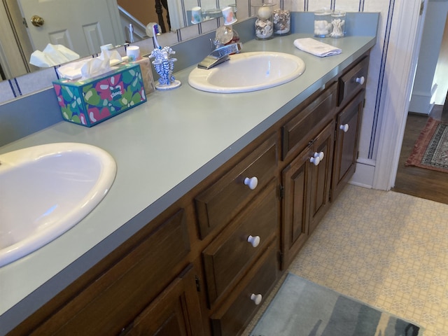 bathroom featuring double vanity, a sink, and tile patterned floors