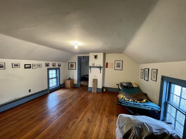 additional living space featuring dark wood-type flooring and vaulted ceiling