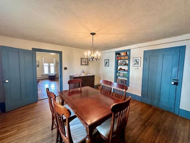 dining room with dark hardwood / wood-style floors, a chandelier, and a textured ceiling