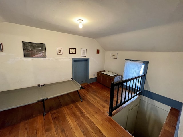 stairway featuring lofted ceiling and hardwood / wood-style floors