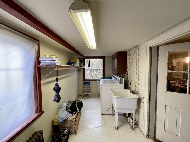 laundry room with cabinets, sink, radiator heating unit, and washing machine and clothes dryer