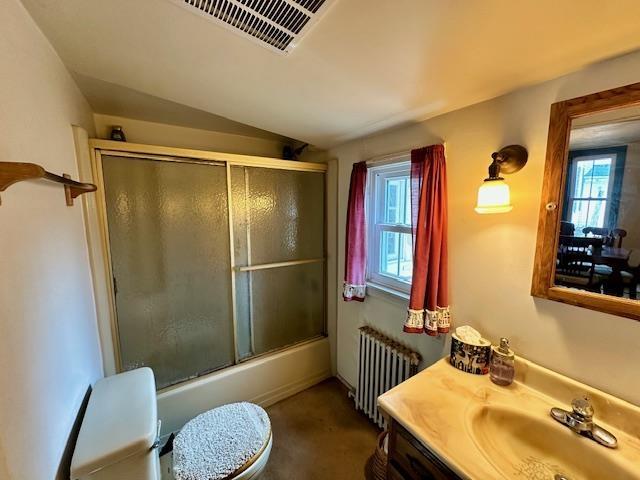 full bathroom with vaulted ceiling, enclosed tub / shower combo, plenty of natural light, and radiator