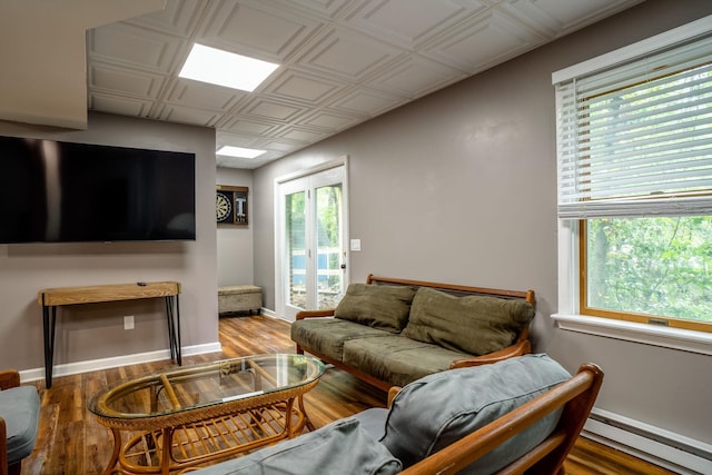 living room featuring wood-type flooring and a baseboard heating unit