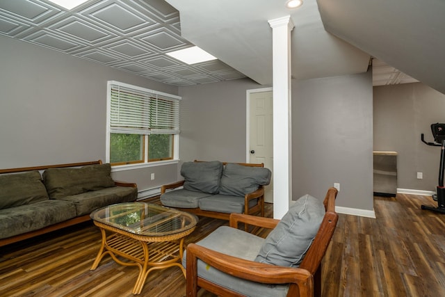 living room with a baseboard heating unit, decorative columns, and dark hardwood / wood-style floors