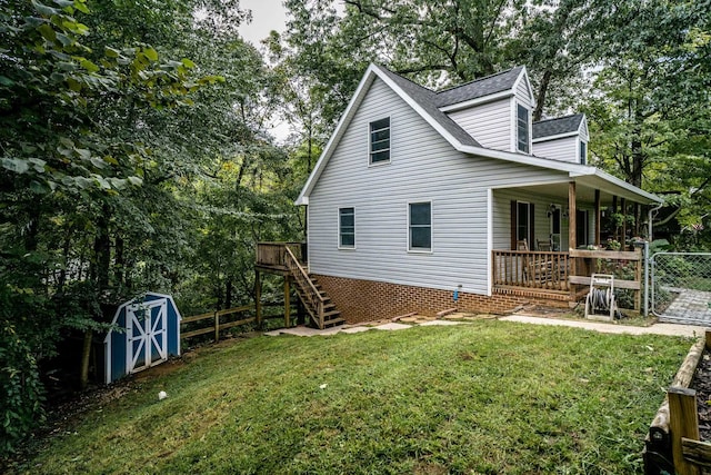 view of side of property with a shed, a lawn, and a porch