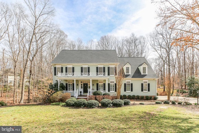 view of front of home with a porch, a shingled roof, and a front lawn