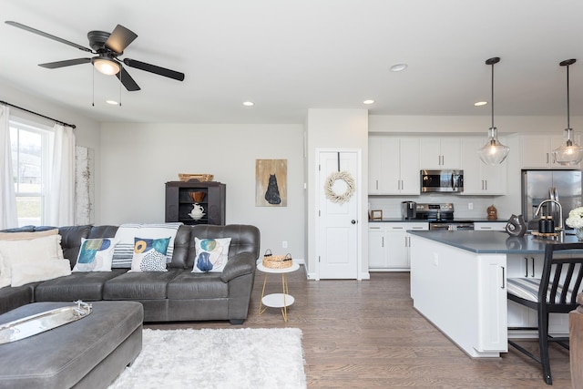 living area featuring a ceiling fan, recessed lighting, and dark wood-style floors