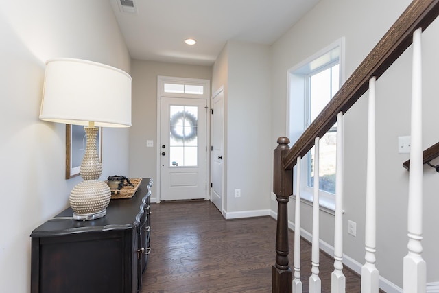 entrance foyer with visible vents, baseboards, dark wood finished floors, and stairs