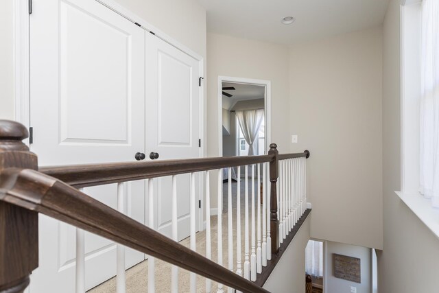 corridor featuring recessed lighting and an upstairs landing