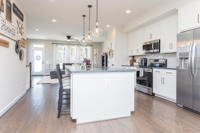 kitchen featuring a sink, dark wood finished floors, tasteful backsplash, and stainless steel appliances