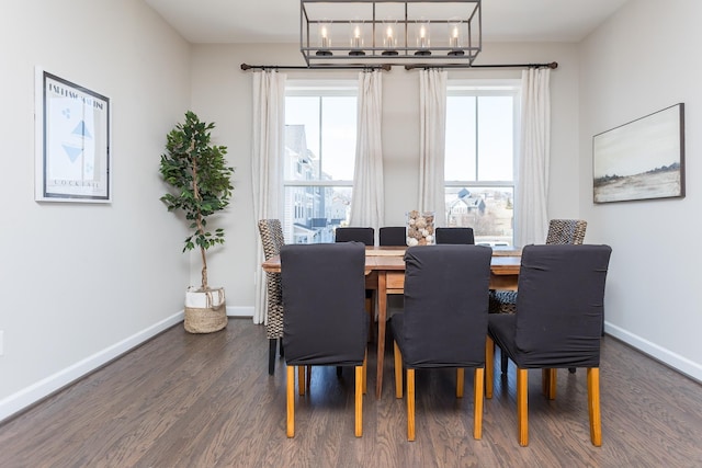 dining space featuring an inviting chandelier, wood finished floors, and baseboards