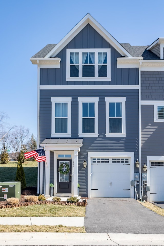 view of front of home featuring aphalt driveway, board and batten siding, and an attached garage