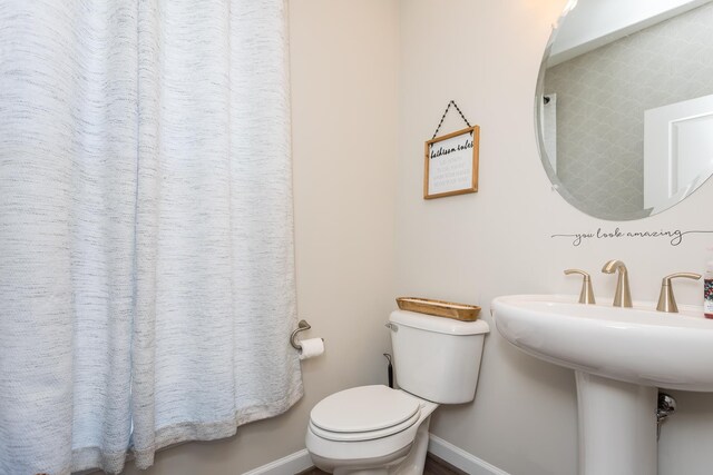 bathroom featuring toilet and baseboards