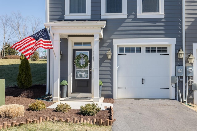 entrance to property featuring a garage and driveway