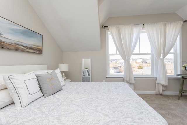 carpeted bedroom featuring baseboards and lofted ceiling