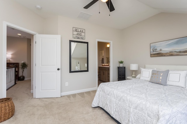 bedroom with light colored carpet, ensuite bath, baseboards, and vaulted ceiling
