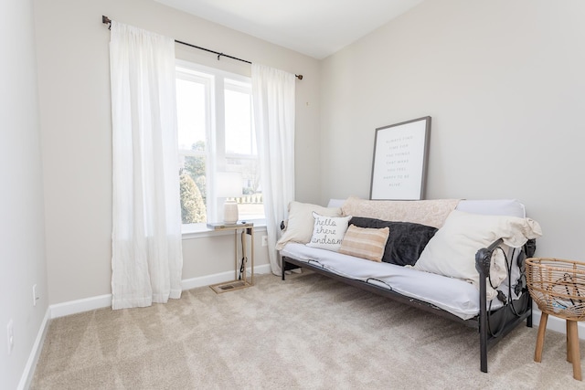 living area with baseboards, carpet floors, and a healthy amount of sunlight