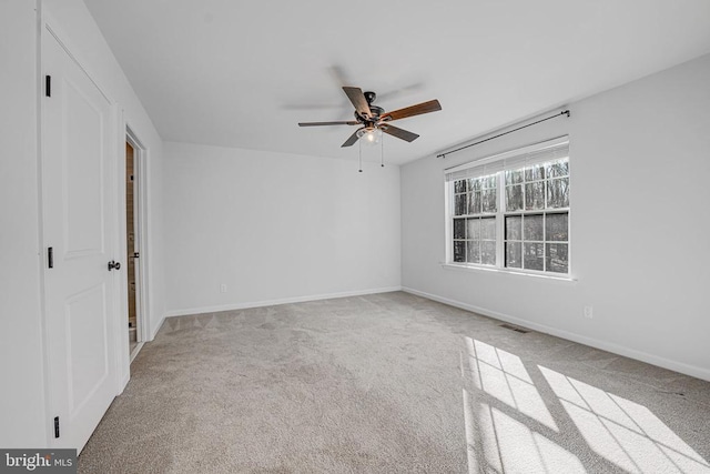 unfurnished room featuring light carpet, ceiling fan, visible vents, and baseboards