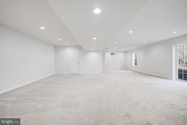 below grade area featuring recessed lighting, light carpet, and baseboards