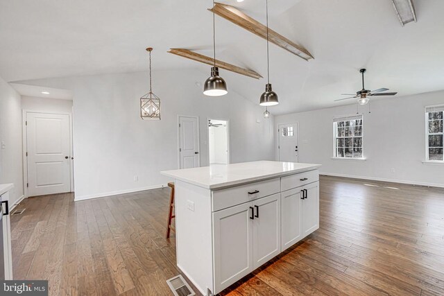 kitchen featuring light countertops, white cabinetry, a kitchen island, and hanging light fixtures