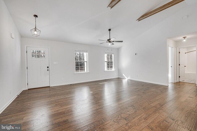 interior space with lofted ceiling, dark wood finished floors, a ceiling fan, and baseboards