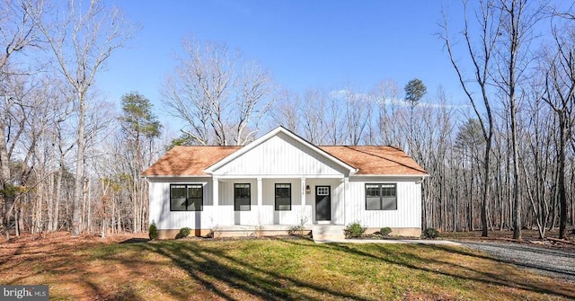 modern farmhouse featuring a front yard and roof with shingles