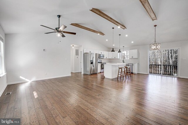 unfurnished living room with dark wood-style flooring, visible vents, beamed ceiling, baseboards, and ceiling fan with notable chandelier