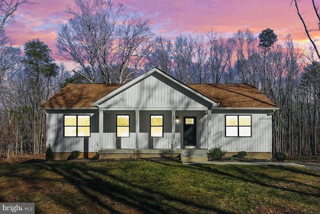 modern inspired farmhouse with roof with shingles and a front yard