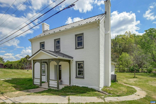 view of front facade with a porch, central AC unit, and a front yard