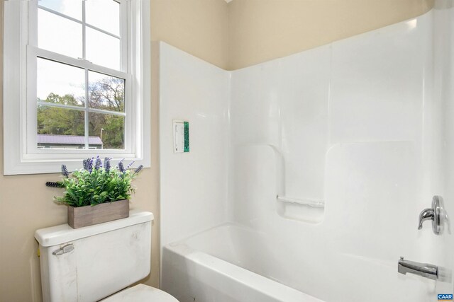 bathroom featuring shower / bathing tub combination and toilet