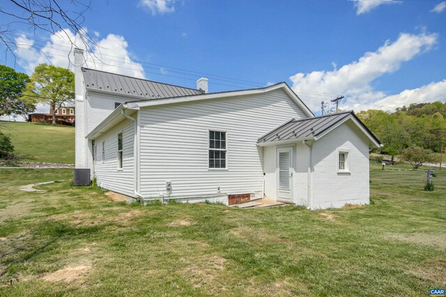 back of house featuring central AC and a lawn