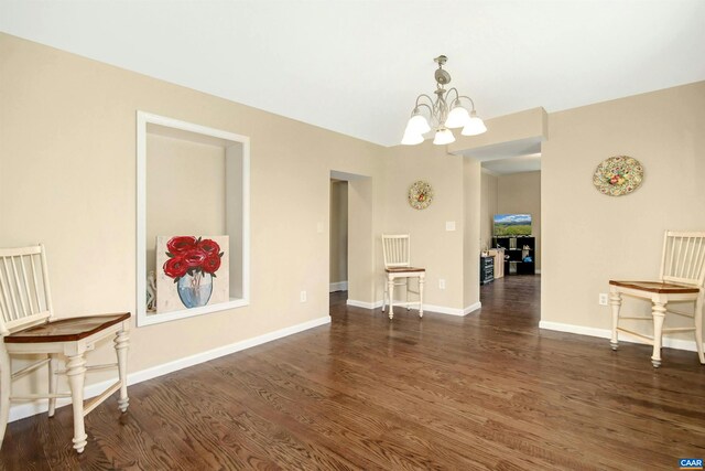 dining space with dark hardwood / wood-style floors and a notable chandelier