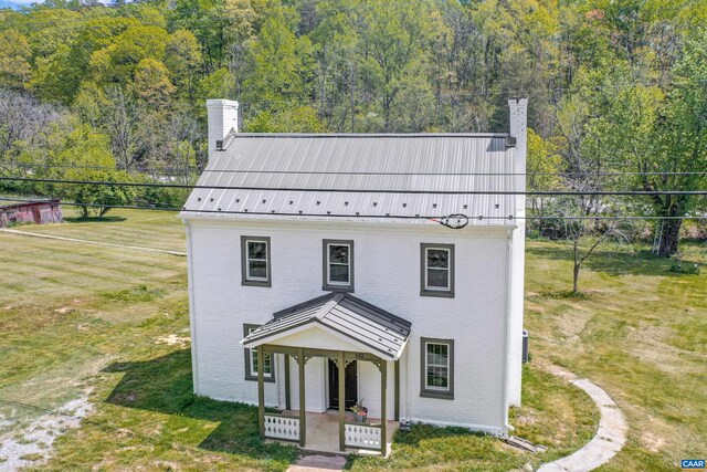 view of front of house with covered porch and a front lawn