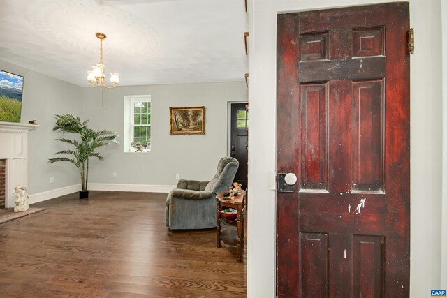 entrance foyer with an inviting chandelier and dark hardwood / wood-style flooring