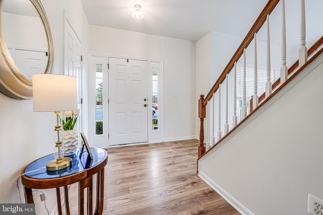 entrance foyer with wood finished floors, baseboards, and stairs