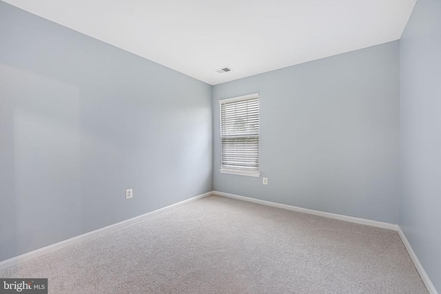 spare room with baseboards, visible vents, and carpet flooring