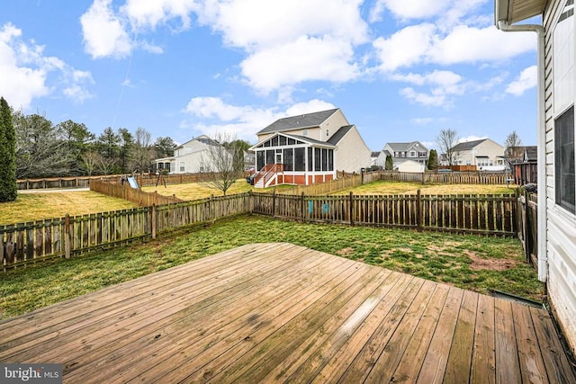 deck with a yard, a fenced backyard, and a sunroom