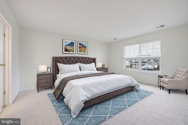 bedroom featuring baseboards, visible vents, and light colored carpet