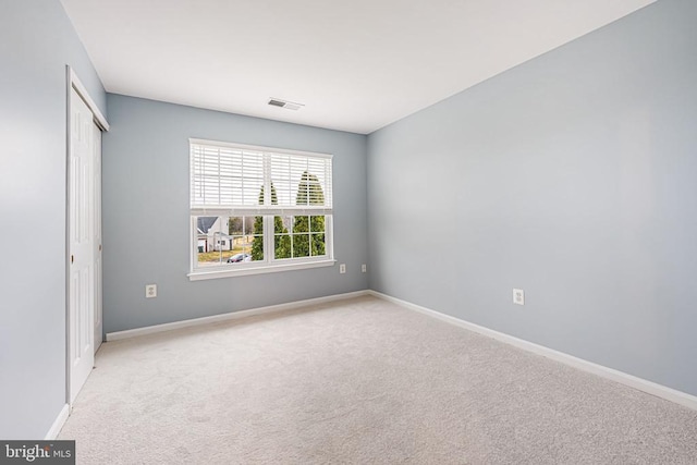 unfurnished bedroom with a closet, carpet flooring, visible vents, and baseboards