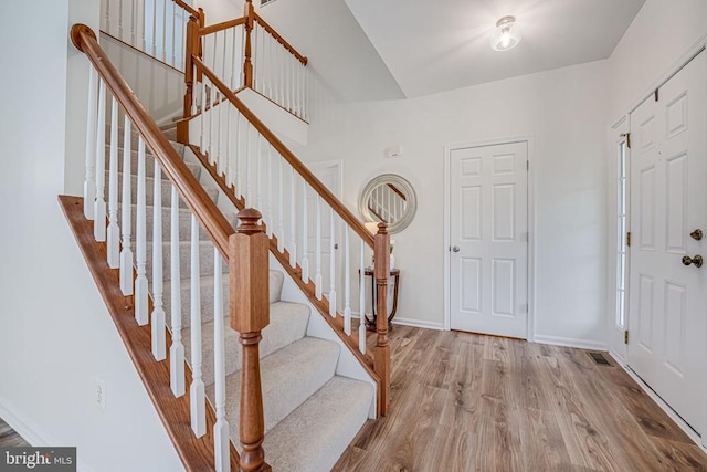 foyer with visible vents, baseboards, and wood finished floors