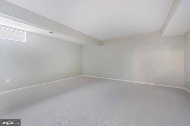 unfurnished room with carpet floors, visible vents, and baseboards