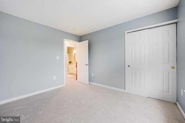 unfurnished bedroom featuring carpet floors, a closet, and baseboards