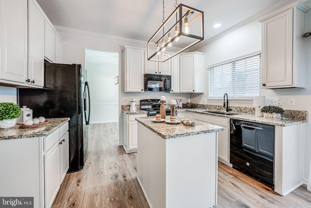 kitchen with a kitchen island, a sink, white cabinetry, ornamental molding, and black appliances