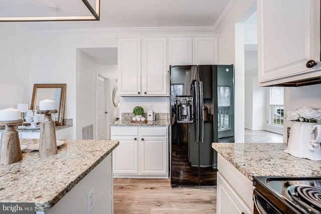 kitchen with crown molding, visible vents, black refrigerator with ice dispenser, light wood-style floors, and white cabinets