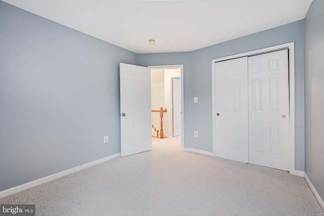 unfurnished bedroom with a closet, carpet flooring, and baseboards