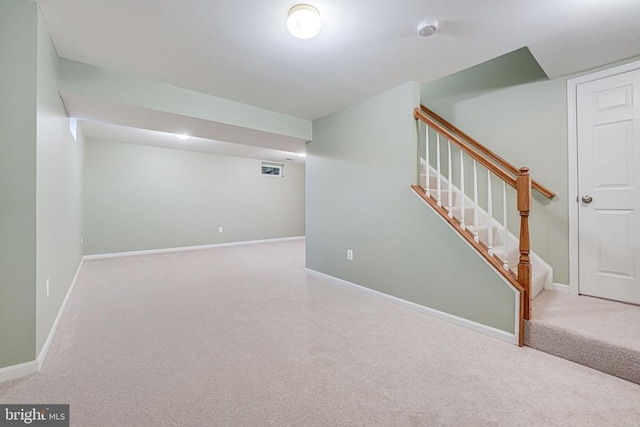 finished basement featuring stairway, carpet flooring, visible vents, and baseboards